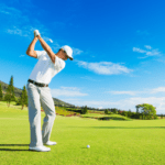 A golfer in mid-swing against a scenic fairway – golf quotes