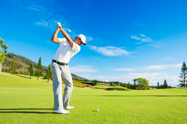 A golfer in mid-swing against a scenic fairway – golf quotes